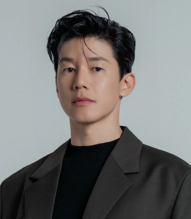 Fotografía de perfil oficial del actor surcoreano Kim Mu-yeol con chaqueta oscura.